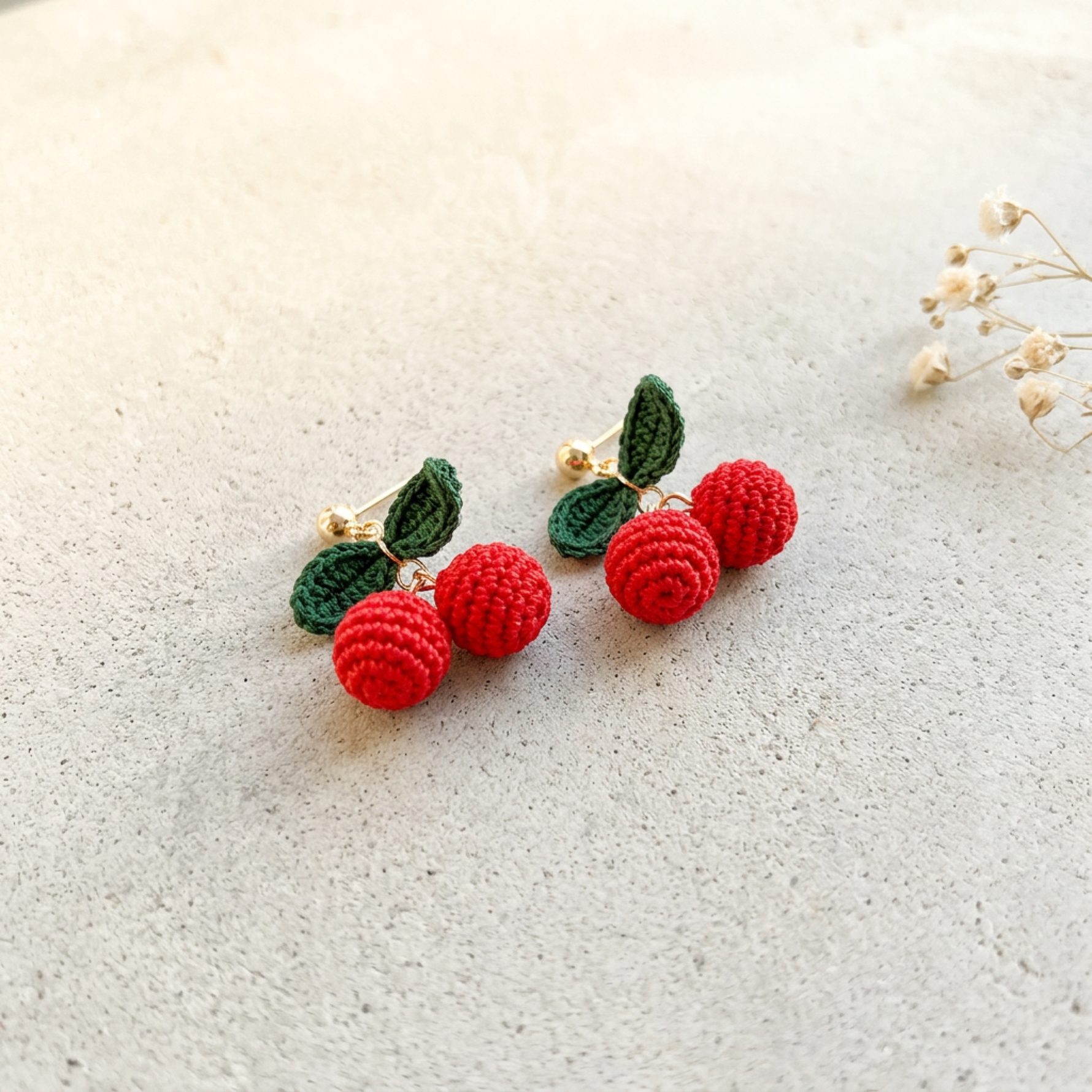 Micro Crochet Cherry Earrings hanging from natural branch