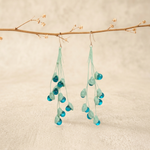 Micro Crochet Lily of the Valley Earrings hanging from natural branch