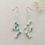 Micro Crochet Lily of the Valley Earrings flat lay with dried flowers