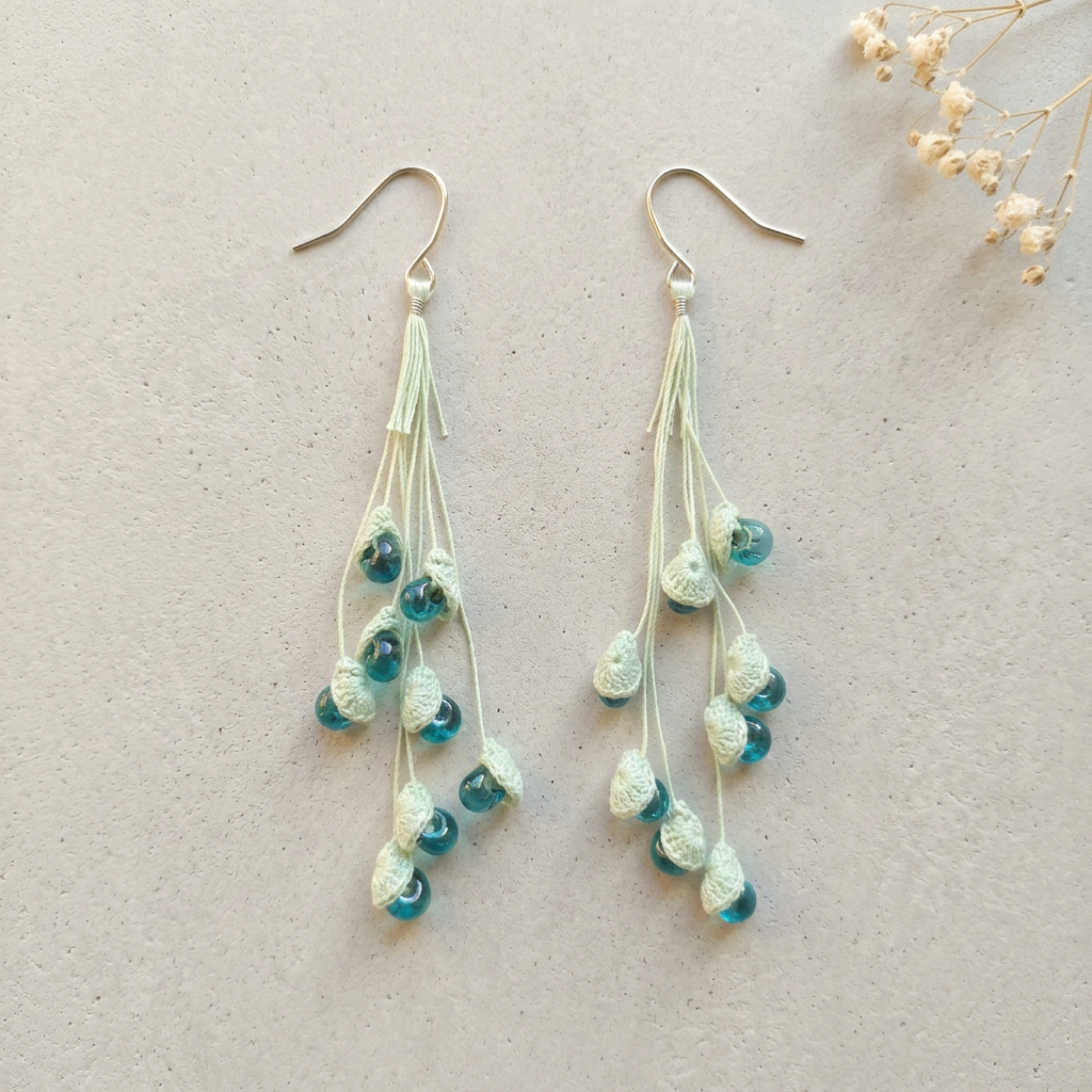 Micro Crochet Lily of the Valley Earrings flat lay with dried flowers