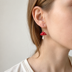Petalore red mushroom micro crochet earrings — close-up wearing view