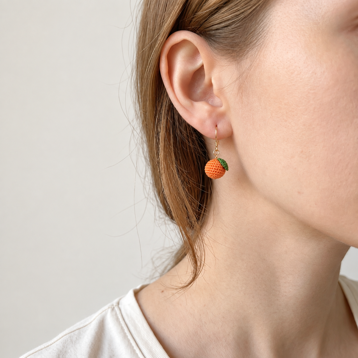 Micro crochet tangerine earrings — close-up wearing view