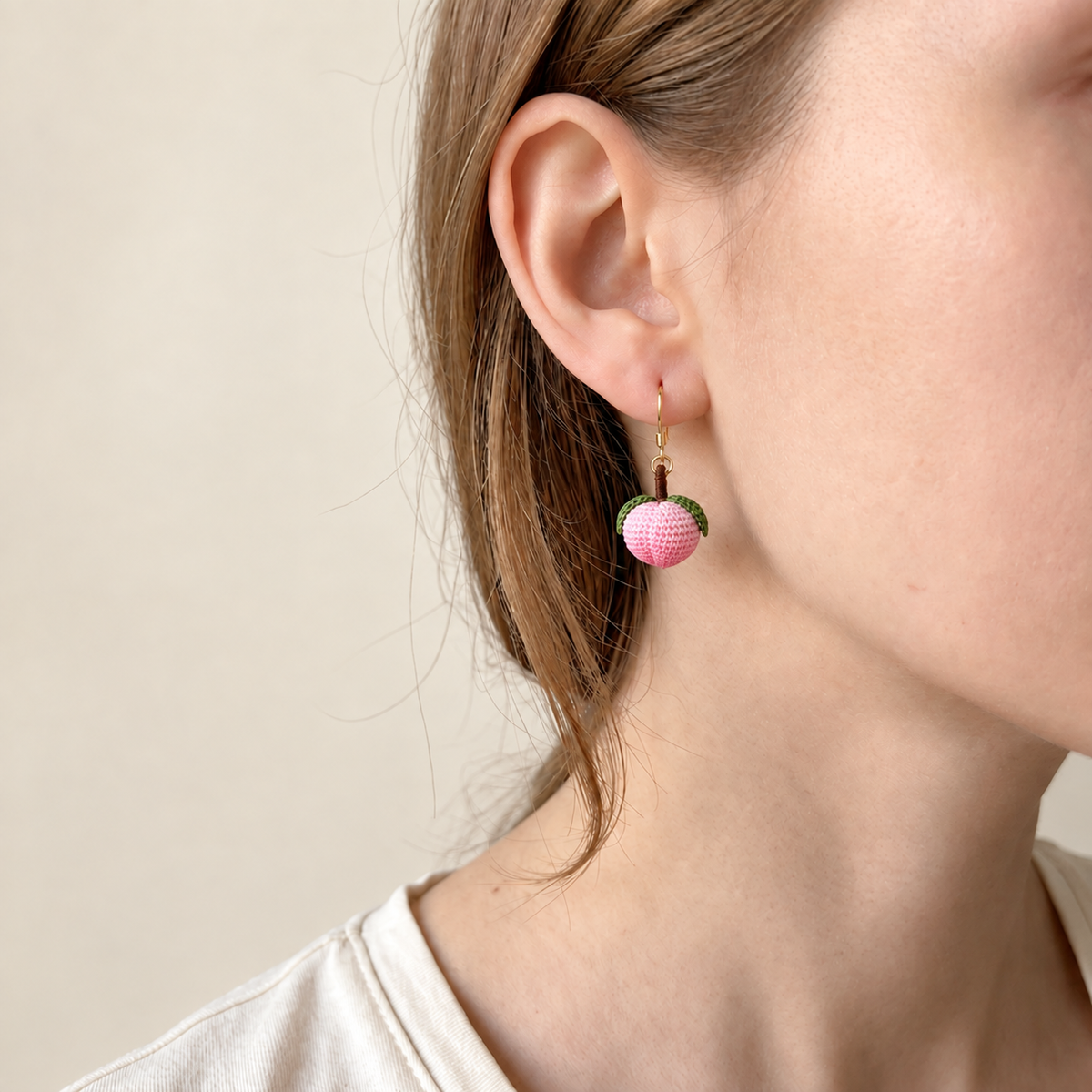 Micro crochet peach earrings — close-up wearing view