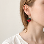 Micro crochet strawberry earrings — close-up wearing view