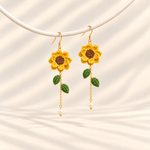 Petalore golden yellow micro crochet sunflower earrings — pair on an ivory display
