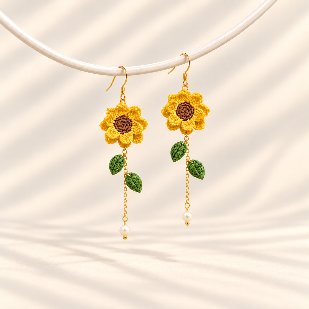 Petalore golden yellow micro crochet sunflower earrings — pair on an ivory display