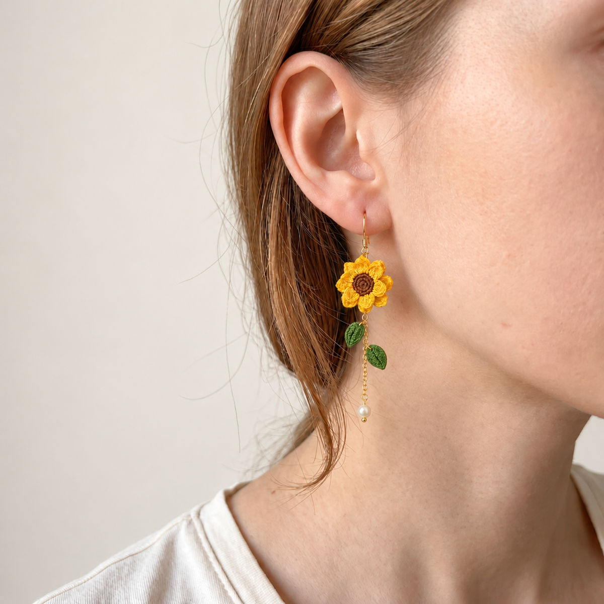 Petalore golden yellow micro crochet sunflower earrings — close-up wearing view