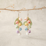 Micro Crochet Rainbow Bell Flower Earrings hanging from natural branch