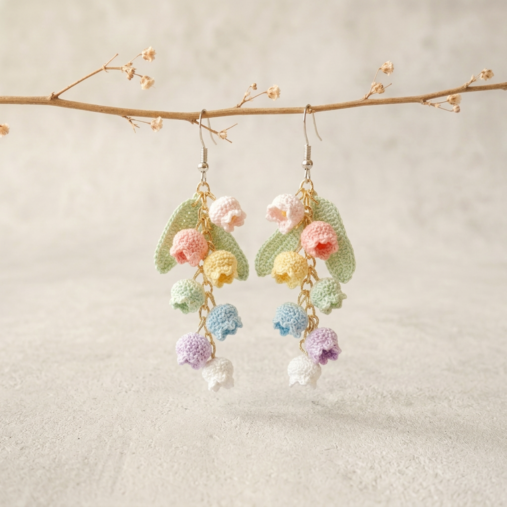 Micro Crochet Rainbow Bell Flower Earrings hanging from natural branch