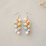 Micro Crochet Rainbow Bell Flower Earrings flat lay with dried flowers