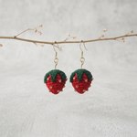 Micro Crochet Strawberry Earrings hanging from natural branch