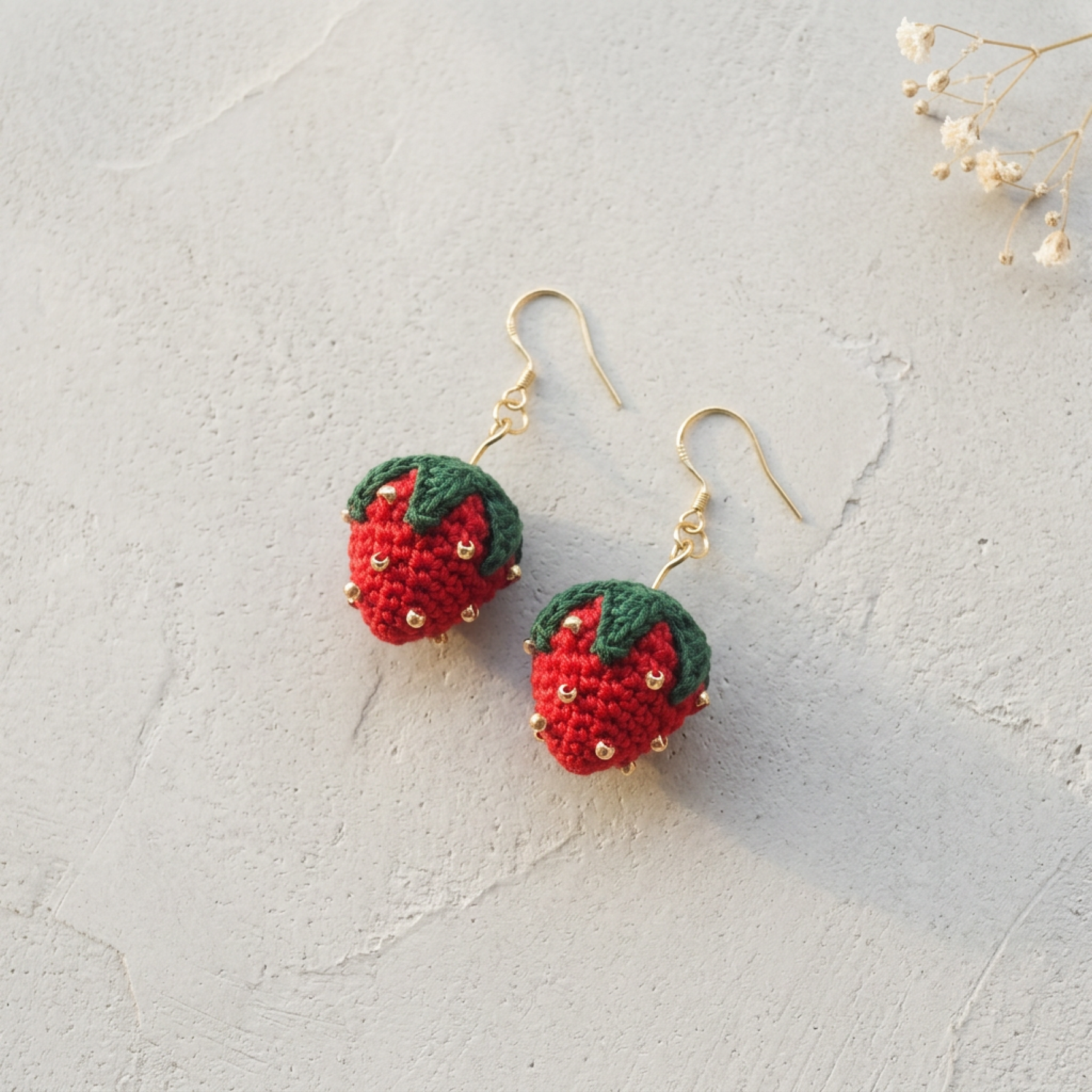 Micro Crochet Strawberry Earrings flat lay with dried flowers