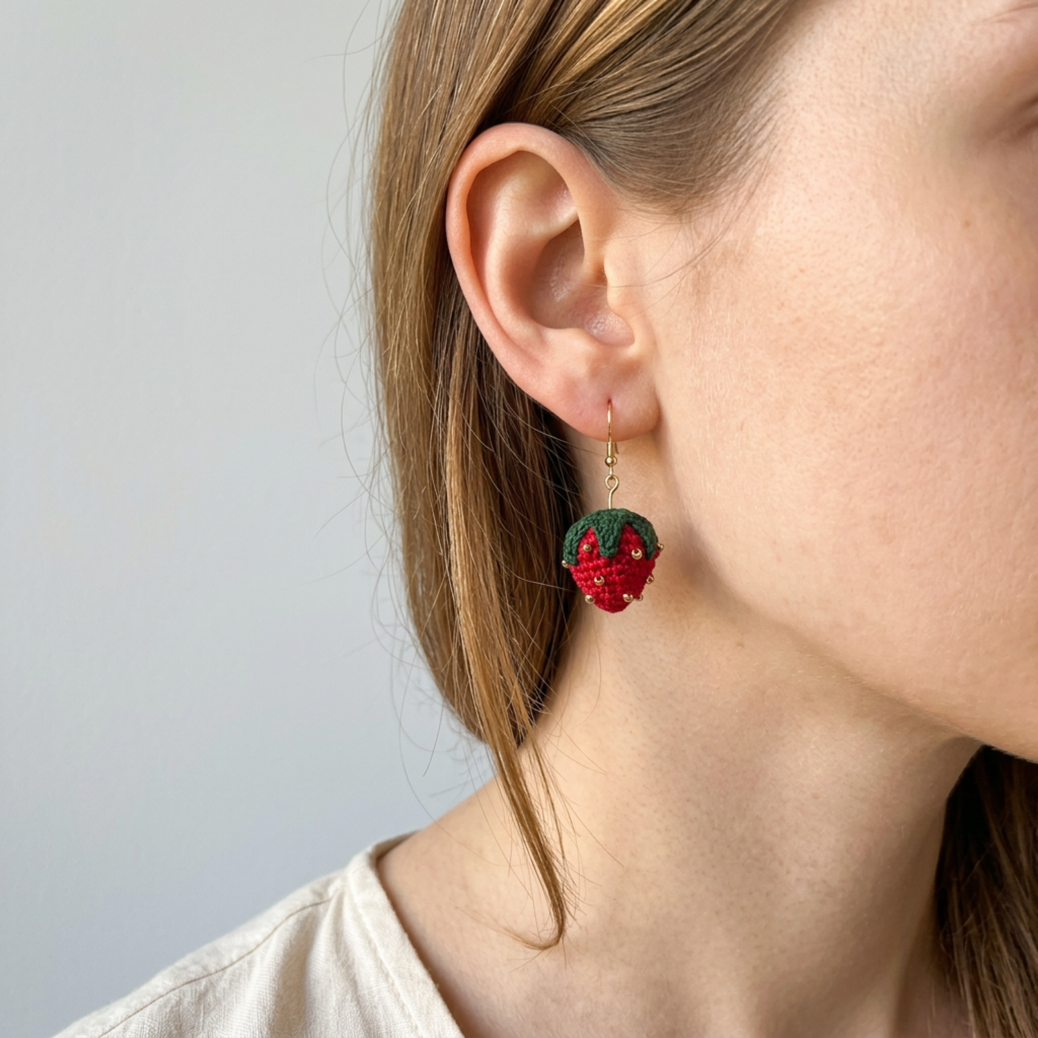 Woman wearing micro crochet strawberry earrings