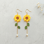 Micro crochet sunflower earrings flat lay with dried flowers
